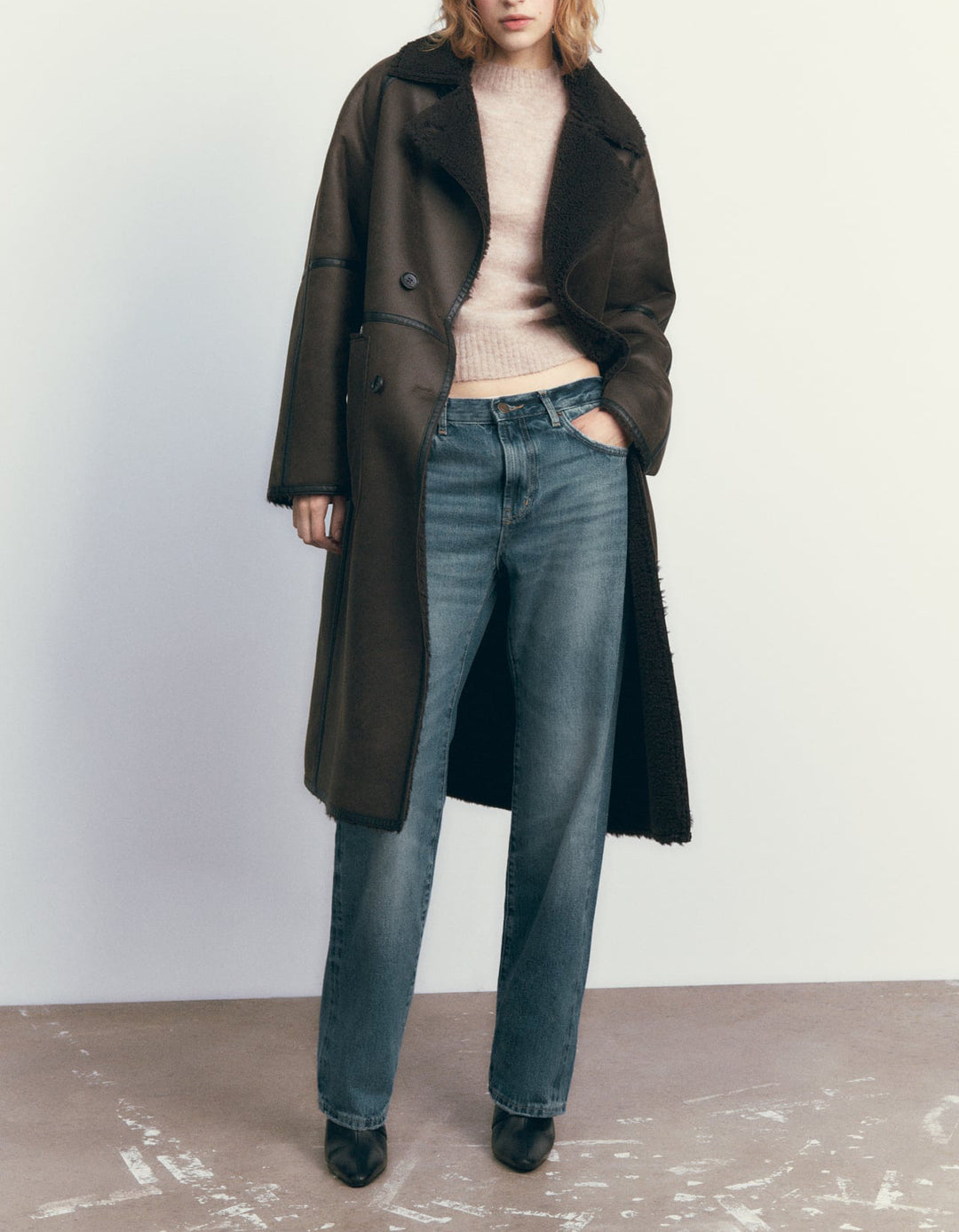 Woman in a belted faux shearling coat