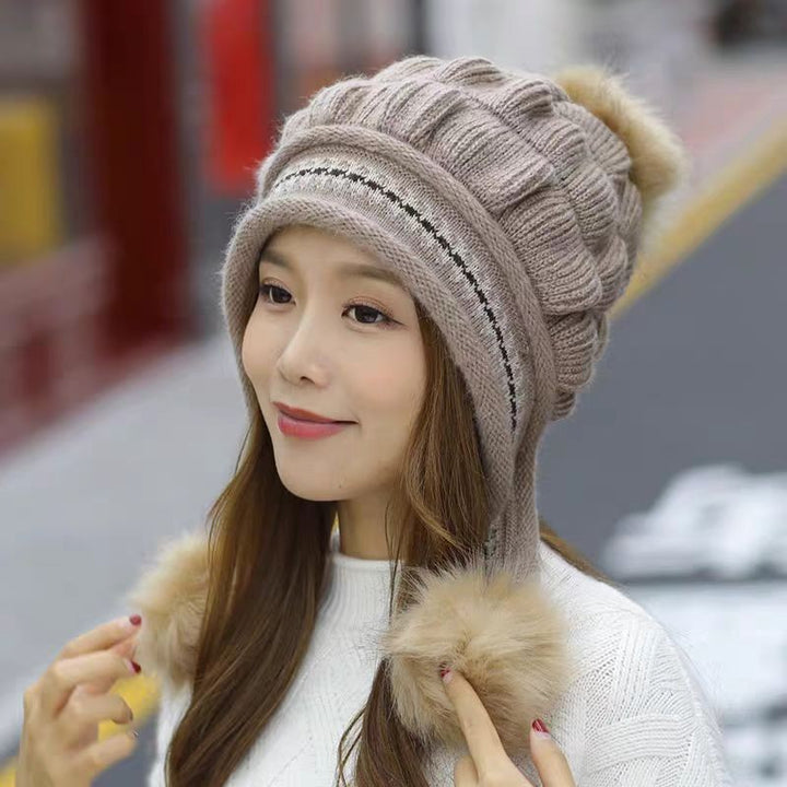 Woman in an ear flap beanie with pompom